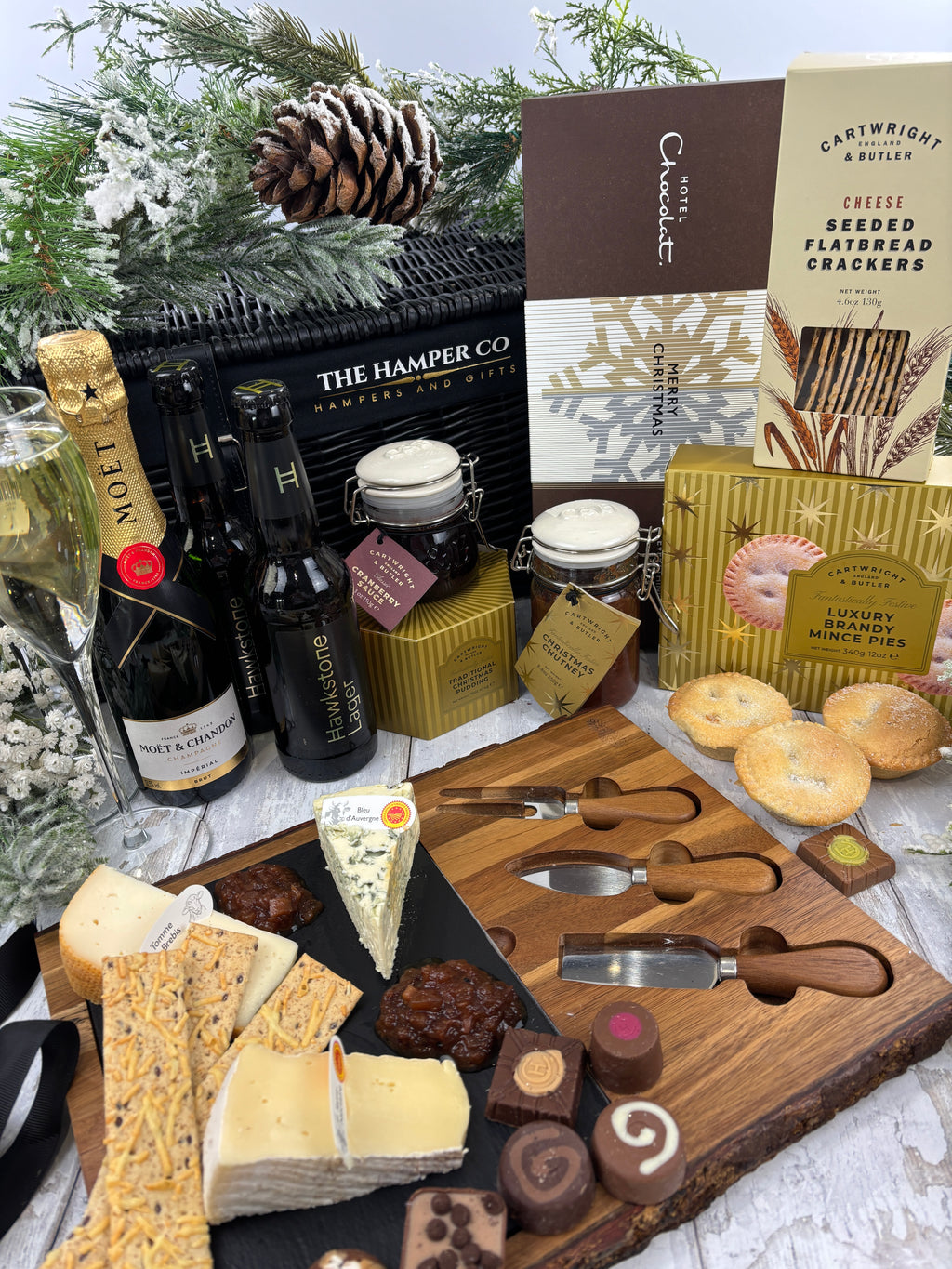 A luxury Christmas charcuterie and cheese gift hamper from The Hamper Co, featuring an assortment His and Hers luxury Christmas hamper with Moët Champagne, Hawkstone Lager, Hotel Chocolat, Cartwright & Butler and artisan cheese