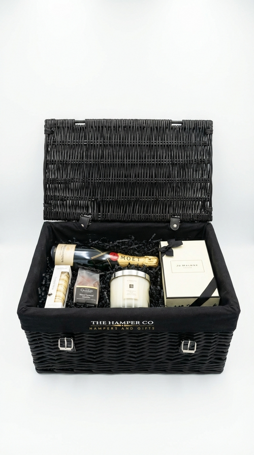 luxury hamper baskets filled with jo malone candle & reed diffser, moet chardon champagne, hotel ouddles and macarons on a white background.